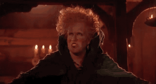 a woman with curly hair and a green cape is making an angry face