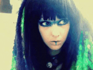 a woman with dreadlocks and a nose ring has a piercing in her lip