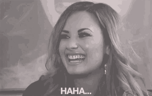 a woman is smiling and laughing in a black and white photo with the words `` haha '' written below her .