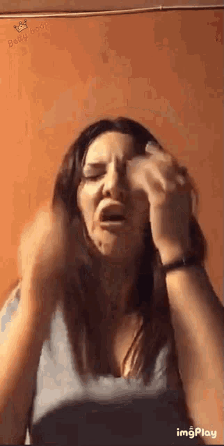 a woman is making a funny face while holding a napkin to her face .