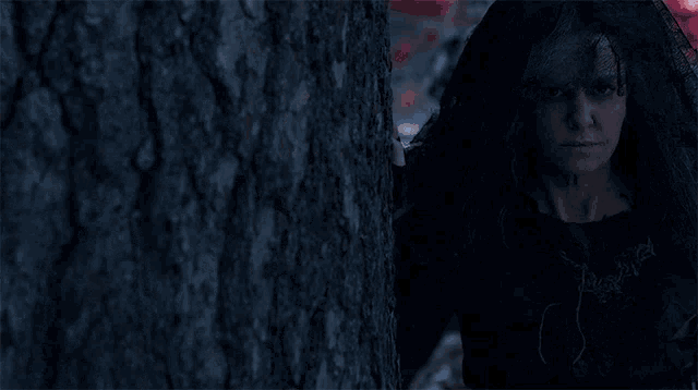 a woman with a black veil on her head looks at the camera