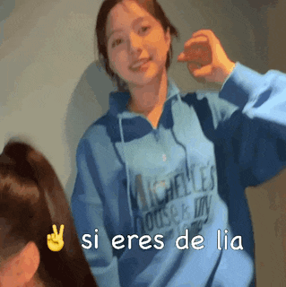 a girl wearing a blue sweatshirt with the words si eres de lia on it