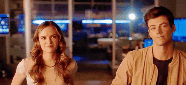 a man and a woman are standing next to each other and smiling .