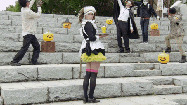 a woman in a maid outfit stands on a set of steps