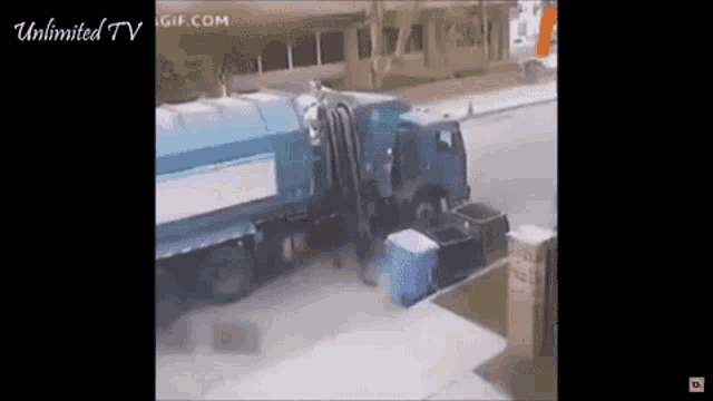a vacuum truck is driving down a street next to a garbage truck .