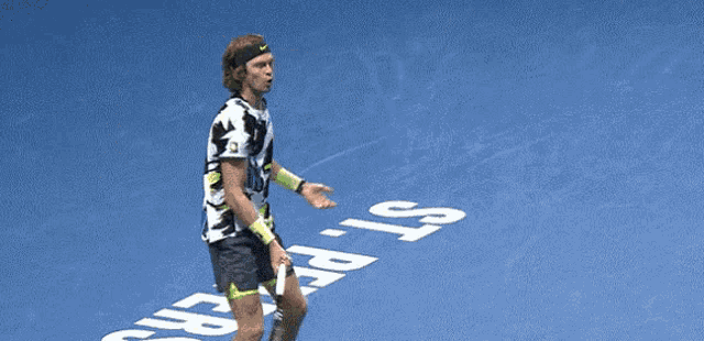 a tennis player wearing a nike headband holds a tennis racquet