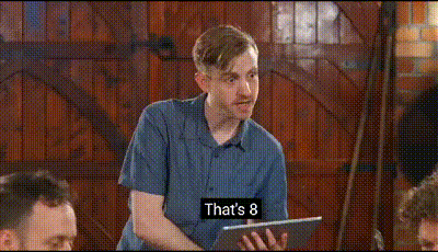 a man in a blue shirt is holding a tablet and saying `` is that an 8 ? ''