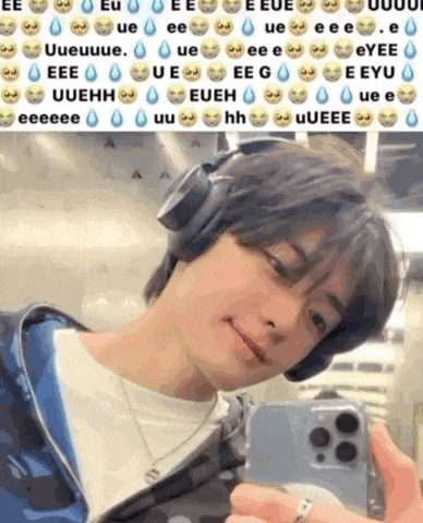 a man wearing headphones is taking a selfie with his cell phone .