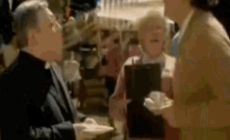 a man and a woman are talking to each other in a crowded area .