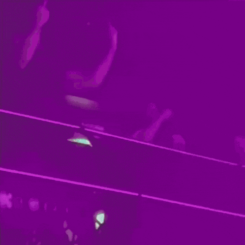 a group of people dancing in a purple room