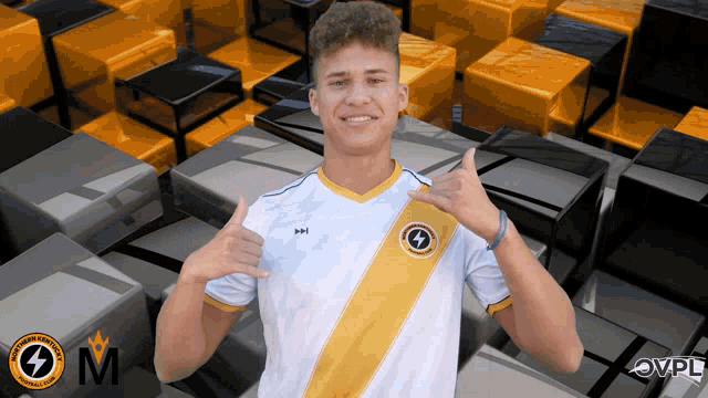 a young man wearing a white shirt with a yellow stripe and the letter m on it