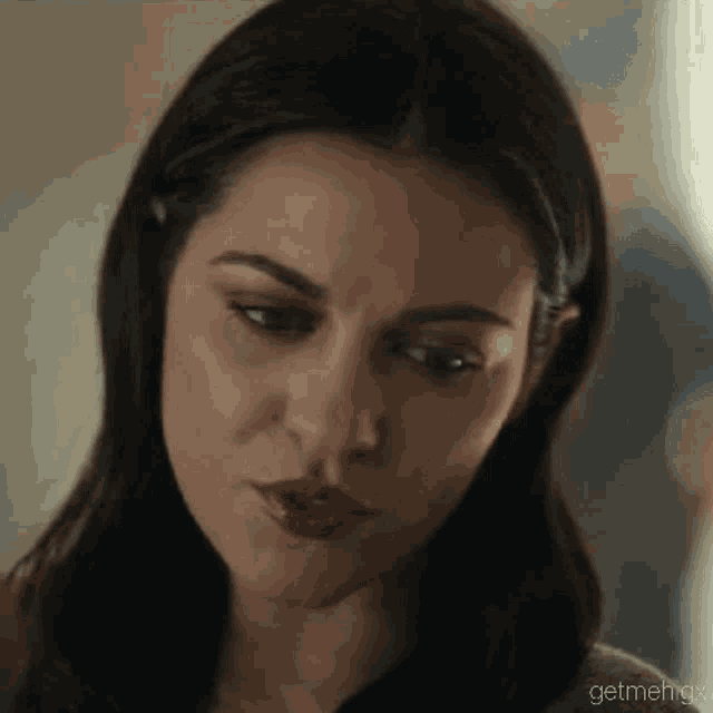 a close up of a woman 's face with a serious expression .