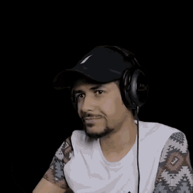 a man wearing headphones and a hat with a white letter s on it