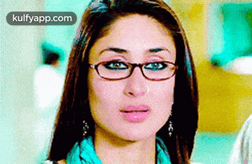 a woman wearing glasses and a scarf is making a funny face .
