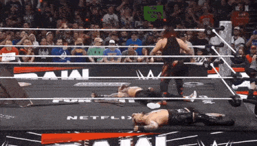 wrestlers in a ring with a sign that says too much oil on it