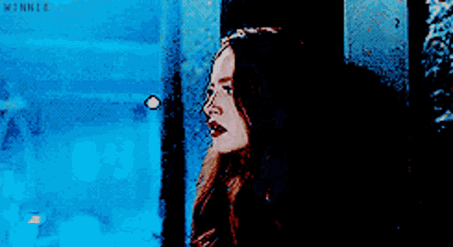 a woman with long red hair is looking up at something