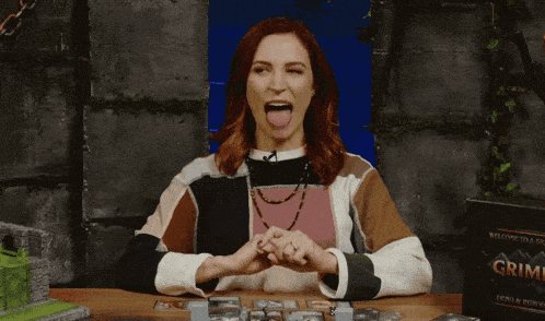 a woman sitting at a table with a box of grime on it