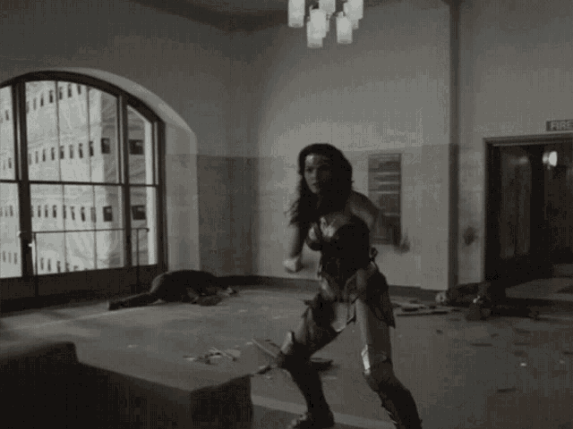 a woman in a wonder woman costume is standing in a room with a sign that says fire