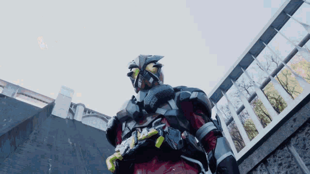 a man in a costume with a green belt is standing in front of a building