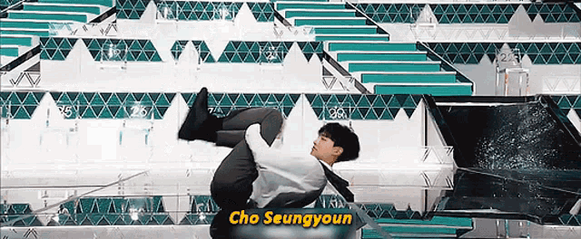 a man is holding another man in his arms and the name cho seungyoun is on the bottom of the screen .