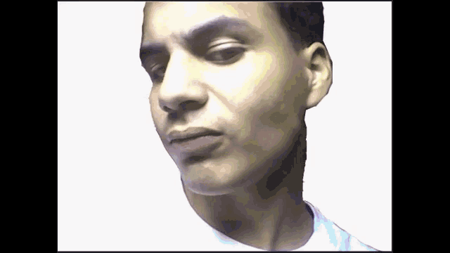 a close up of a man 's face with a white shirt on