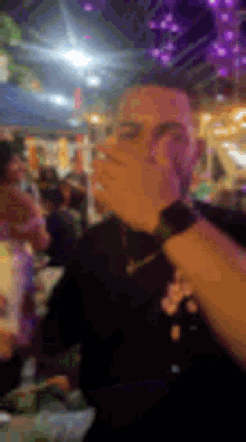 a blurry picture of a man holding a microphone in front of a crowd .