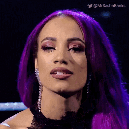 a woman with purple hair is wearing a black top and earrings .