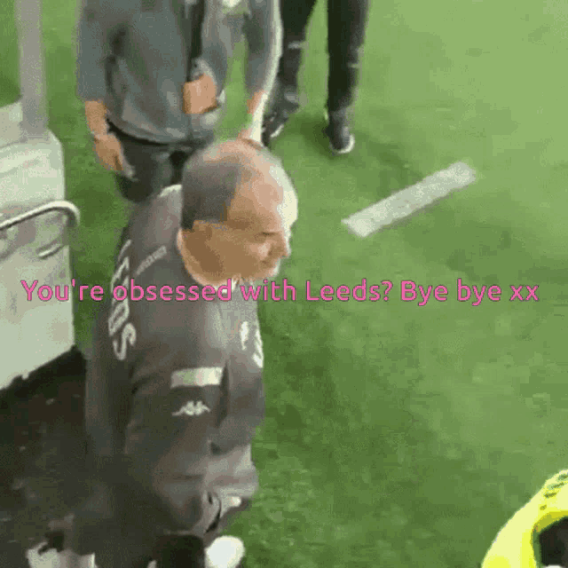 a man standing on a field with the words you 're obsessed with leeds bye bye xxx
