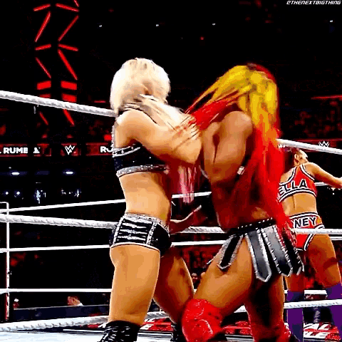 a couple of women wrestling in a ring .