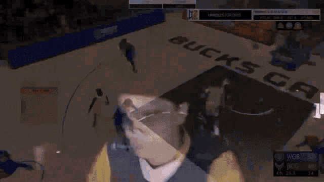 a man wearing a bucks gaming hoodie is sitting in front of a wall