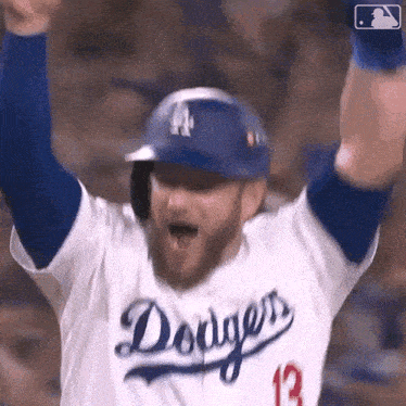 a baseball player wearing a dodgers jersey is celebrating with his arms in the air .