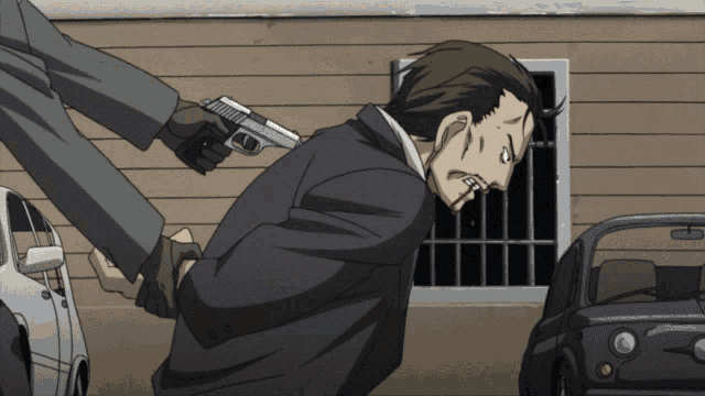 a man in a suit is being held by another man with a gun in his hand