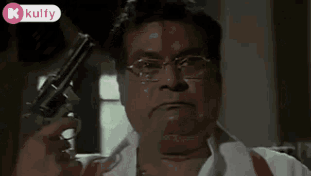 a man is holding a gun in his hand and crying .