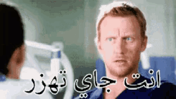 a man with a beard is talking to a woman in a hospital room in arabic .