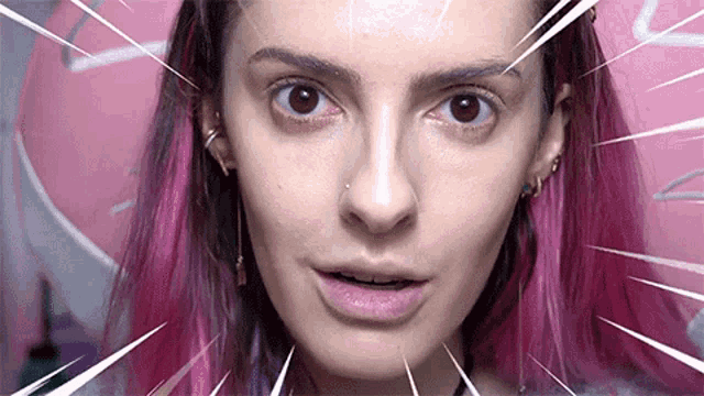 a woman with pink hair is making a funny face in front of a pink background .