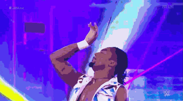 a man in a white and blue outfit is dancing in front of a purple background with the letters w on it