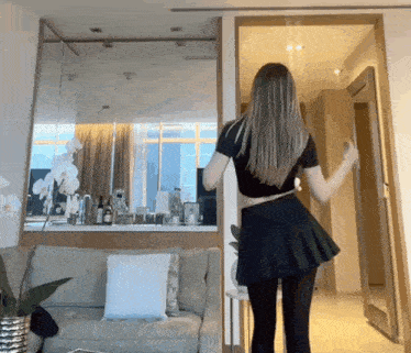 a woman in a black skirt is standing in a room