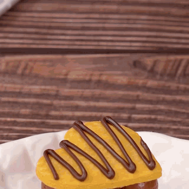 a heart shaped cookie with chocolate icing on it on a white plate
