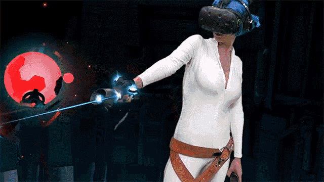 a woman is wearing a virtual reality headset and holding a sword while playing a video game .