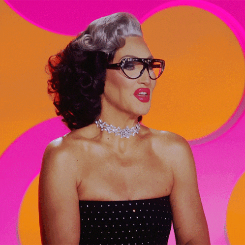 a woman wearing glasses and a choker smiles