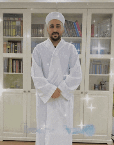 a man in a white robe is standing in front of a bookcase with the words inam-i-han written on the bottom