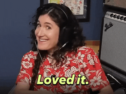 a woman wearing headphones is smiling and says loved it