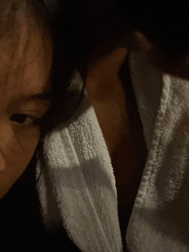 a close up of a person 's face with a towel around their neck