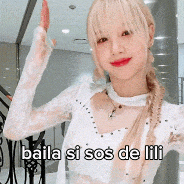 a woman in a white top with the words baila si sos de lili