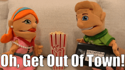 a couple of puppets sitting next to a box of popcorn and a vhs tape that says uh get out of town