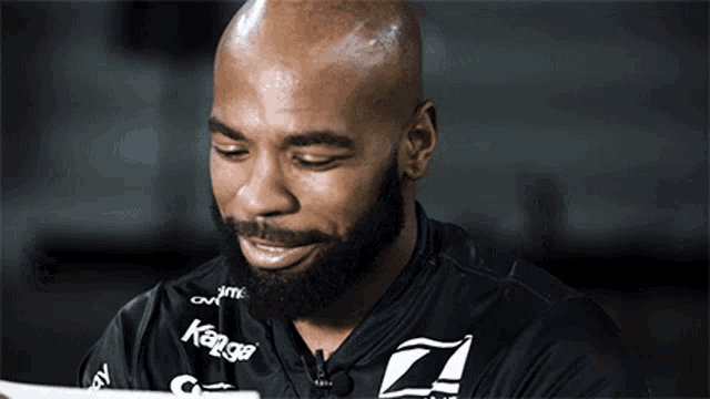 a man with a beard is wearing a black shirt that says kango