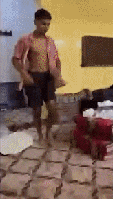 a shirtless man is dancing in a room