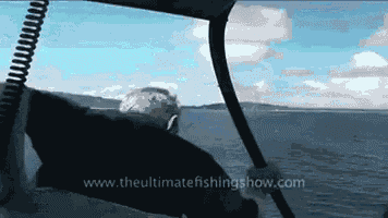 a man on a boat with the website www.theultimatefishingshow.com written on the bottom