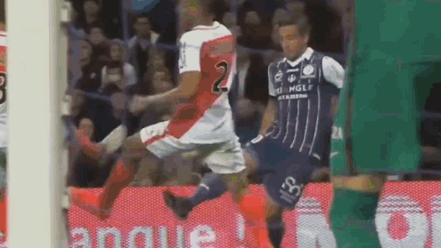a soccer player with the number 2 on his jersey kicks the ball