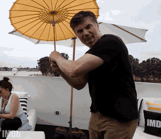 a man holding a yellow umbrella with imdb written on the bottom